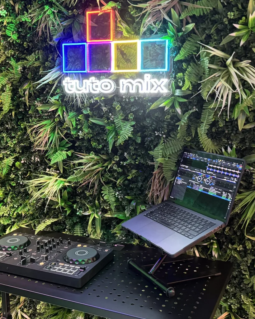 Studio Tuto Mix : contrôleur DJ et ordinateur devant le néon Tuto Mix
